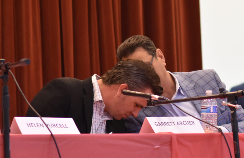 Steve Chucri whispers to Garrett Archer at Election Integrity Panel 2019